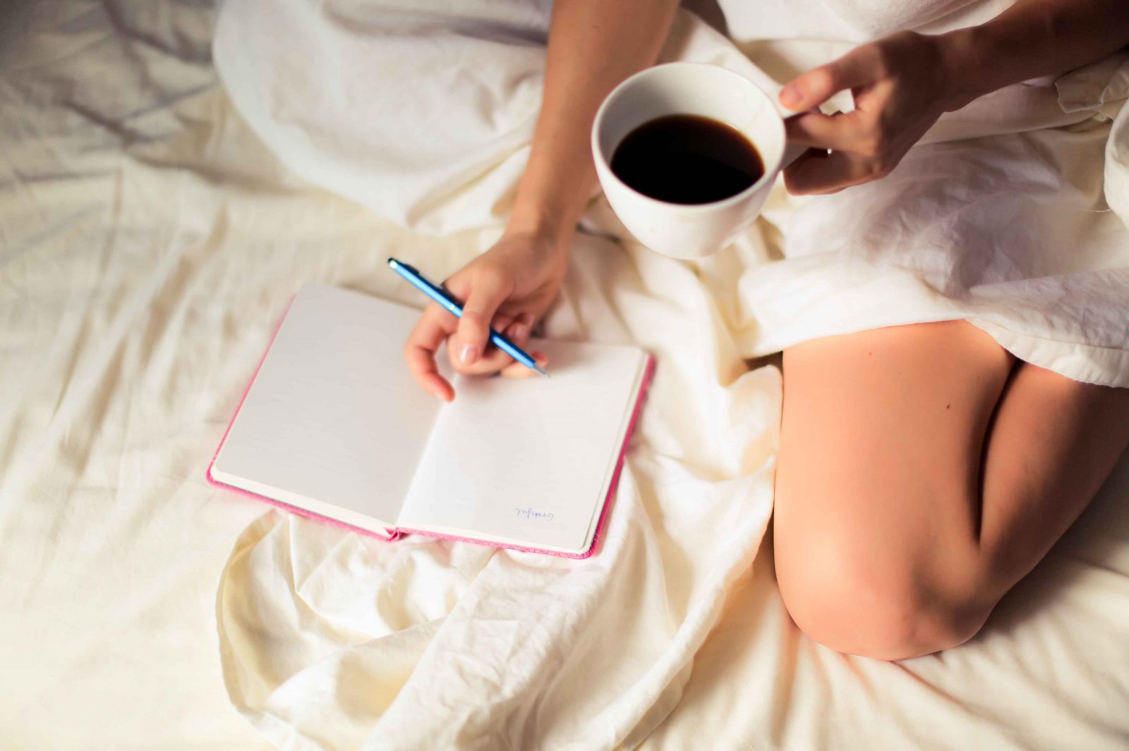 picture of a woman journaling with a journal and morning coffee.
