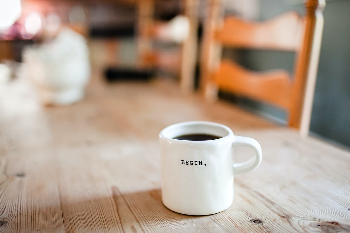 Coffee photography: a mug with 'Begin' engraved to illustrate getting over the motivation barriers and getting started