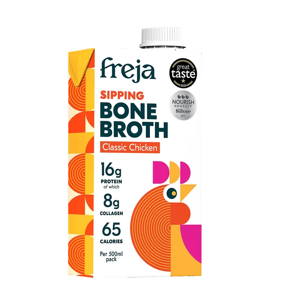 A 500ml carton of Freja Sipping Bone Broth Classic Chicken, featuring a white background with a colorful design of orange, yellow, and pink geometric patterns and a stylized chicken illustration.
