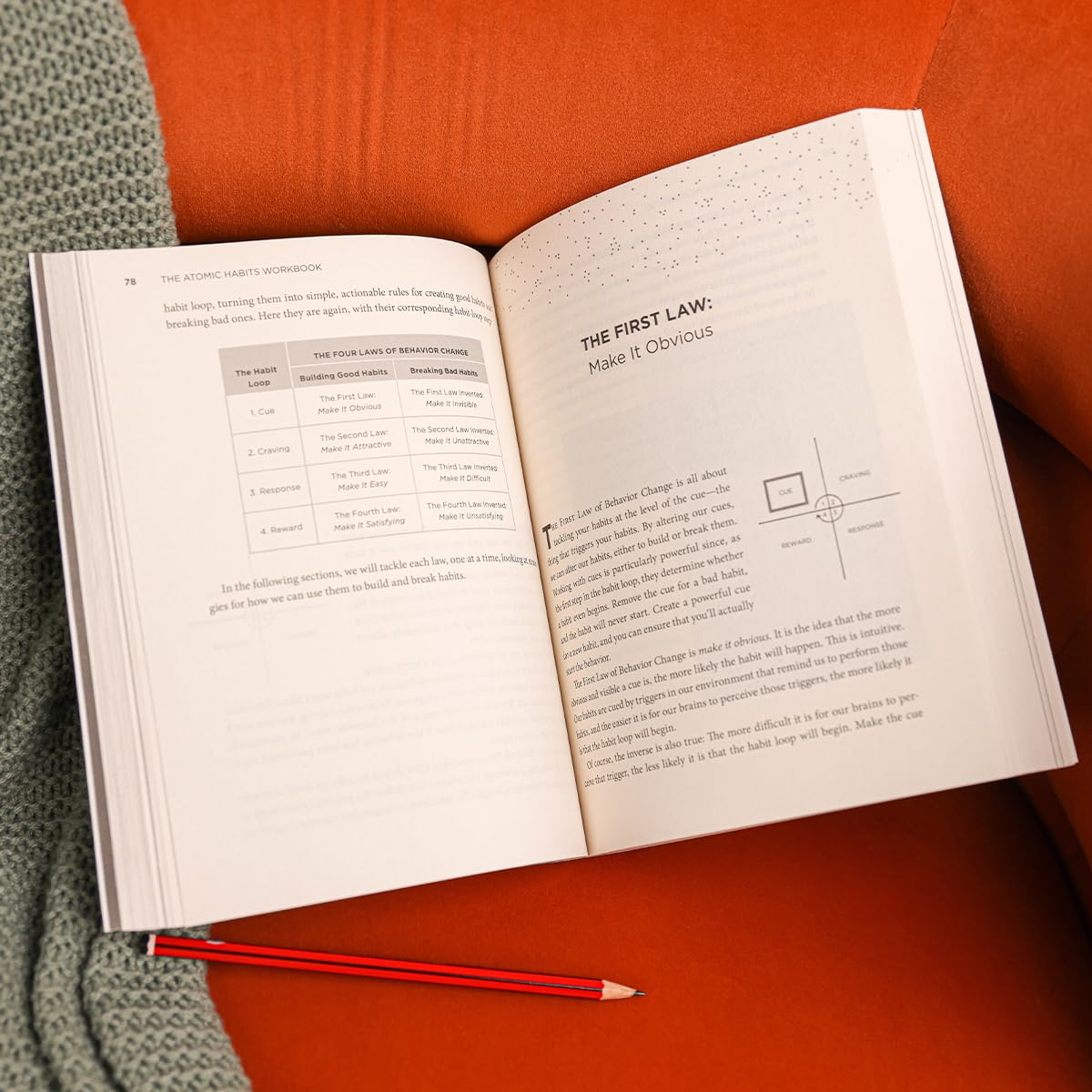 Open book on a red surface with a pencil next to it