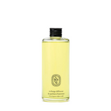 A clear glass bottle of Diptyque Parfum d'Intérés recharge diffusant filled with pale yellow liquid, featuring a black ribbed cap and a gold brand logo on the front, set against a plain white background.