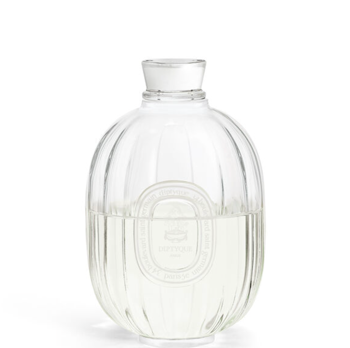 A clear ribbed glass bottle with a matching glass stopper, shown on a white background. The bottle has a circular embossed logo in the centre.