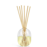 A reed diffuser with a clear ribbed glass bottle filled with pale yellow liquid, topped with six natural bamboo reeds, on a solid white background.