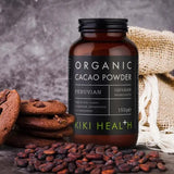 KIKI Health Organic Cacao Powder bottle with cookies and cacao beans on a dark background