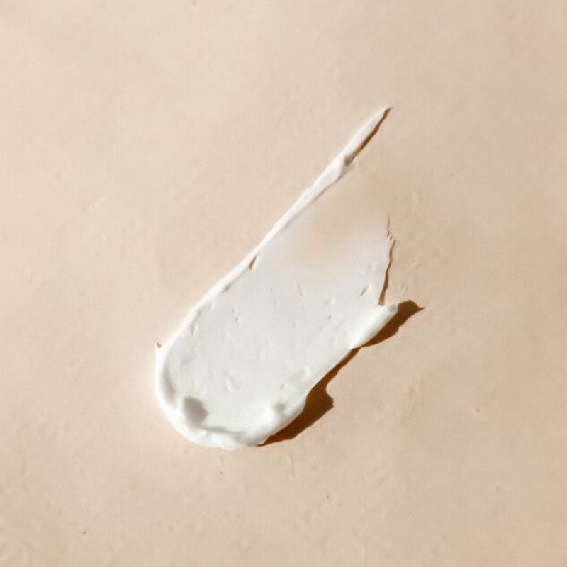 Swatch of body cream on a cream background