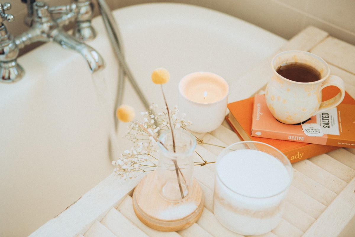 Morning setup of a candle and mug of tea on a bath tray