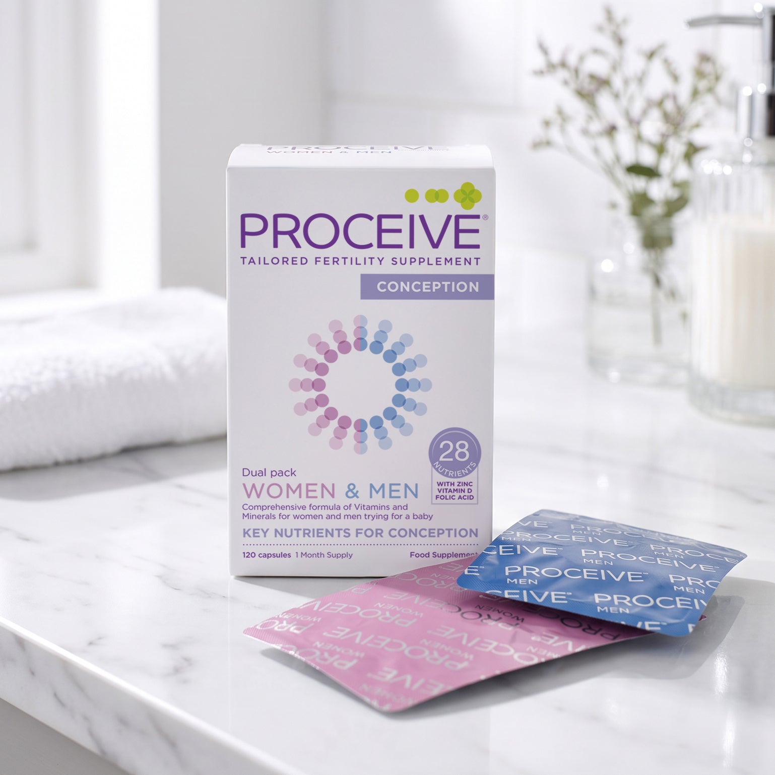 Proceive Conception tailored fertility supplement box on a white marble countertop with two sachets, one pink and one blue, in front of it. The background shows a softly blurred bathroom setting with a towel and soap dispenser.