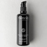 A 100ml black pump bottle of Twelve Beauty Purifying Cleansing Beauty Cream, set against a textured light gray background.